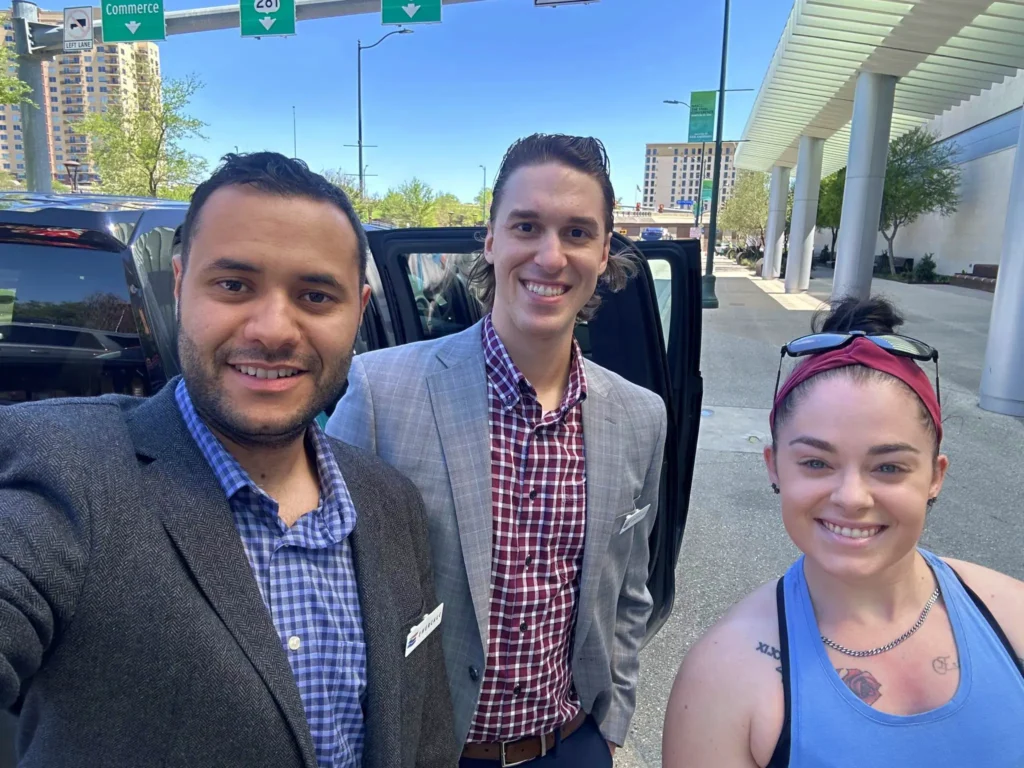Seth and Mack passing 2 donated TVs to a Magdalena House representative.